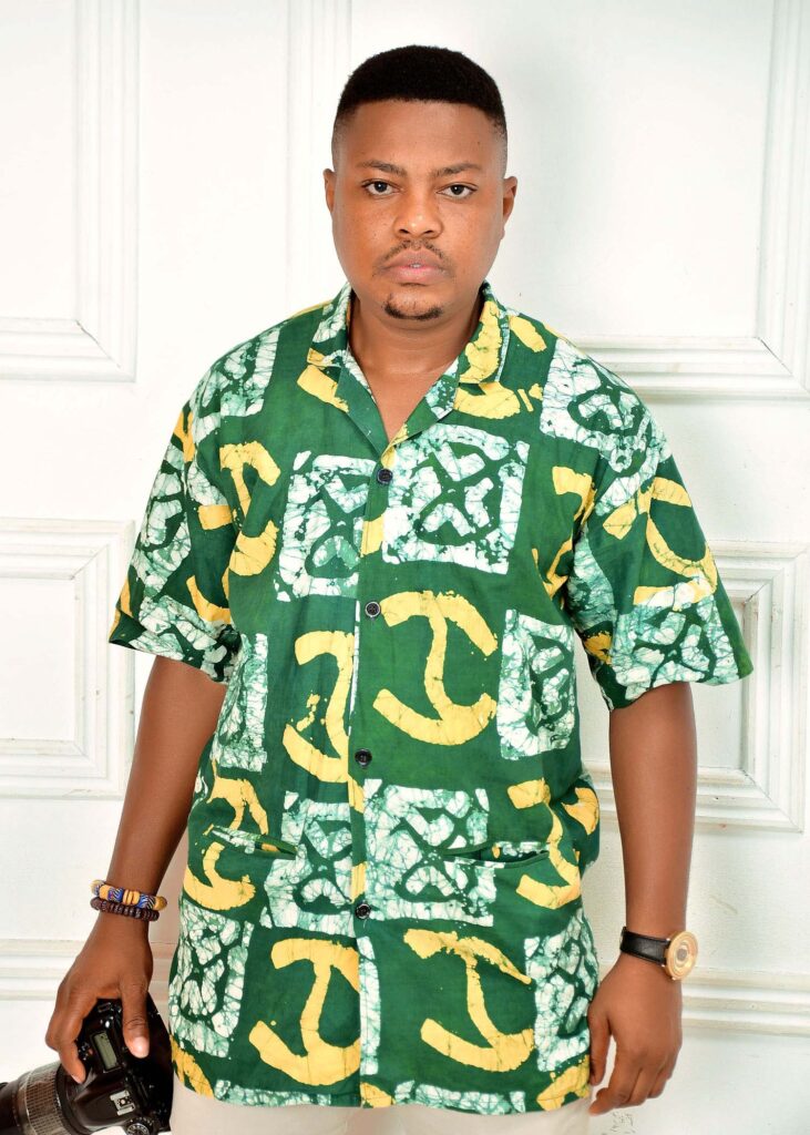 Portrait of Ezra, a professional photographer in Takoradi, holding a camera.