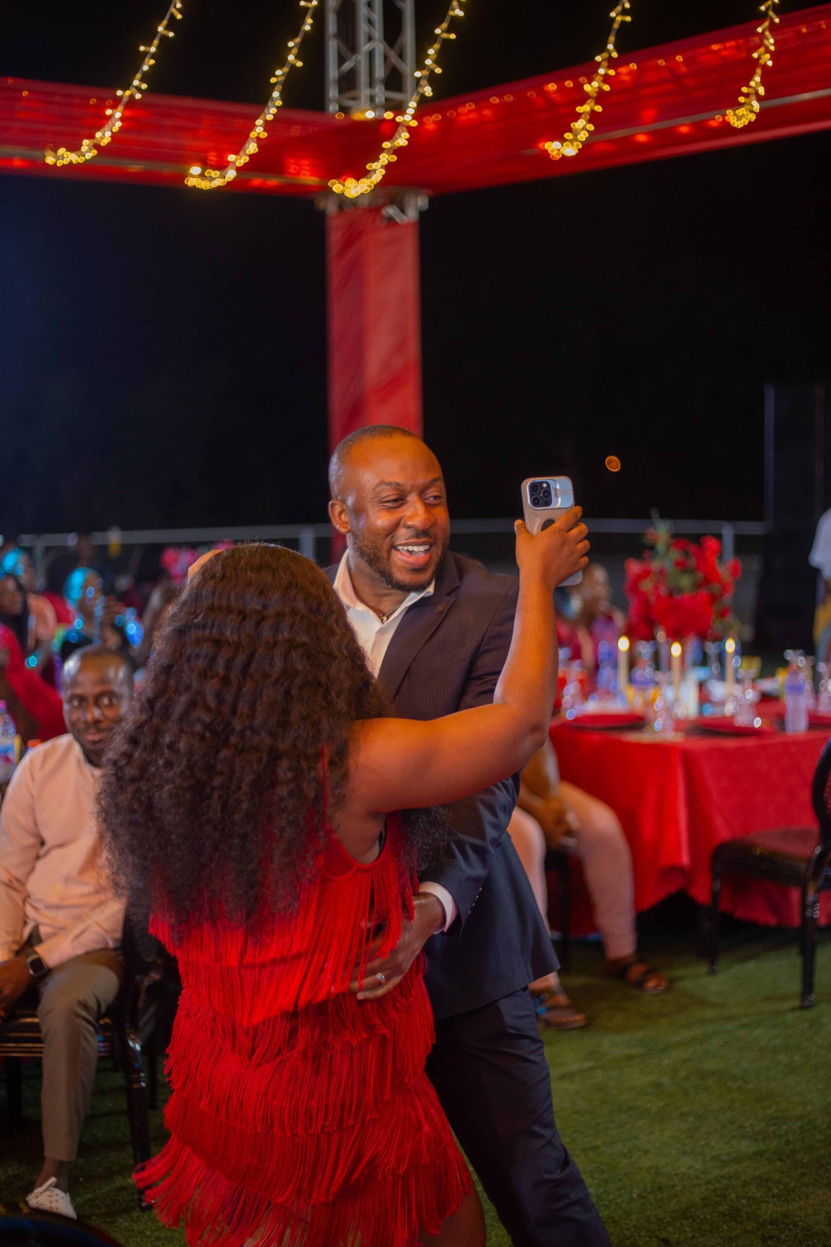 Couple dancing together at a Valentine’s Day event decorated with red and heart-themed décor