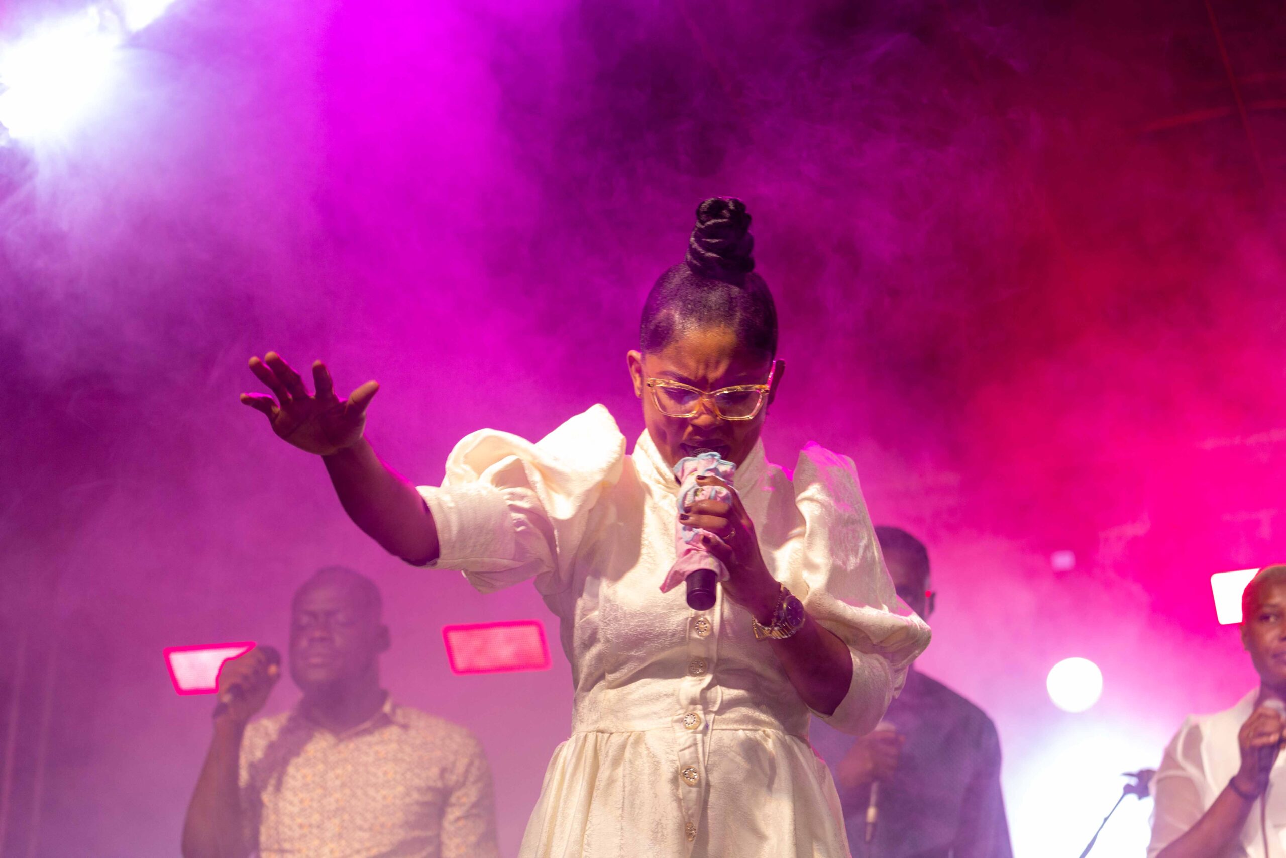 Medium shot of a gospel singer passionately performing on stage during an event.