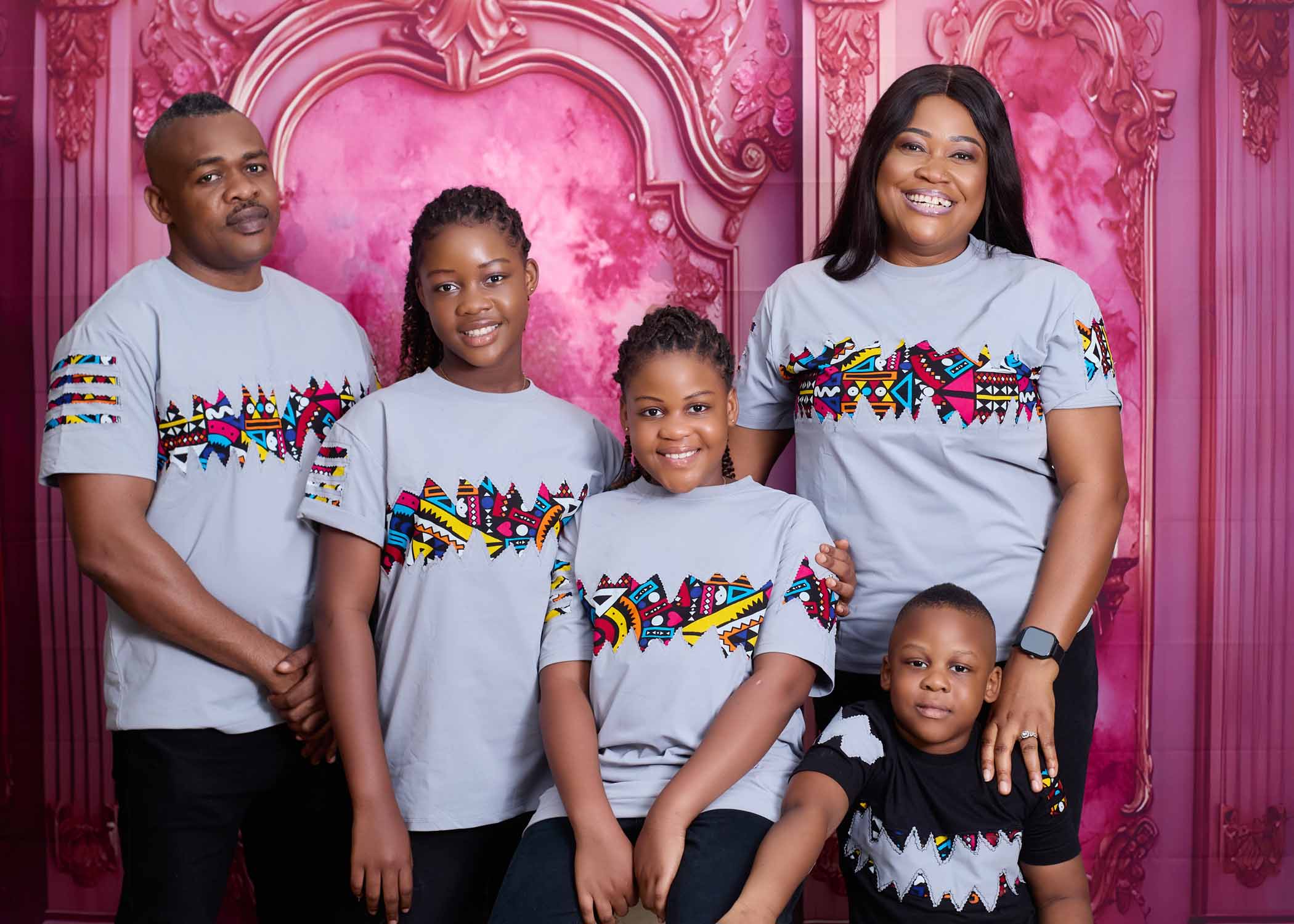 Indoor studio portrait of a smiling family posing together.